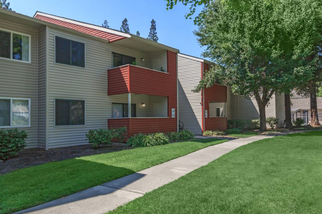 Building exterior with sidewalk and large trees