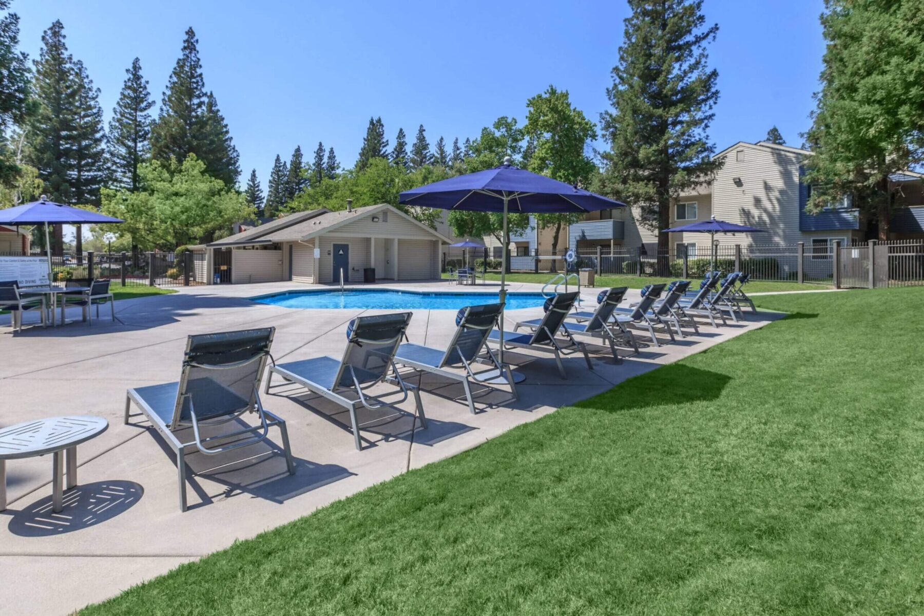 Pool deck with tables, chairs, and umbrellas